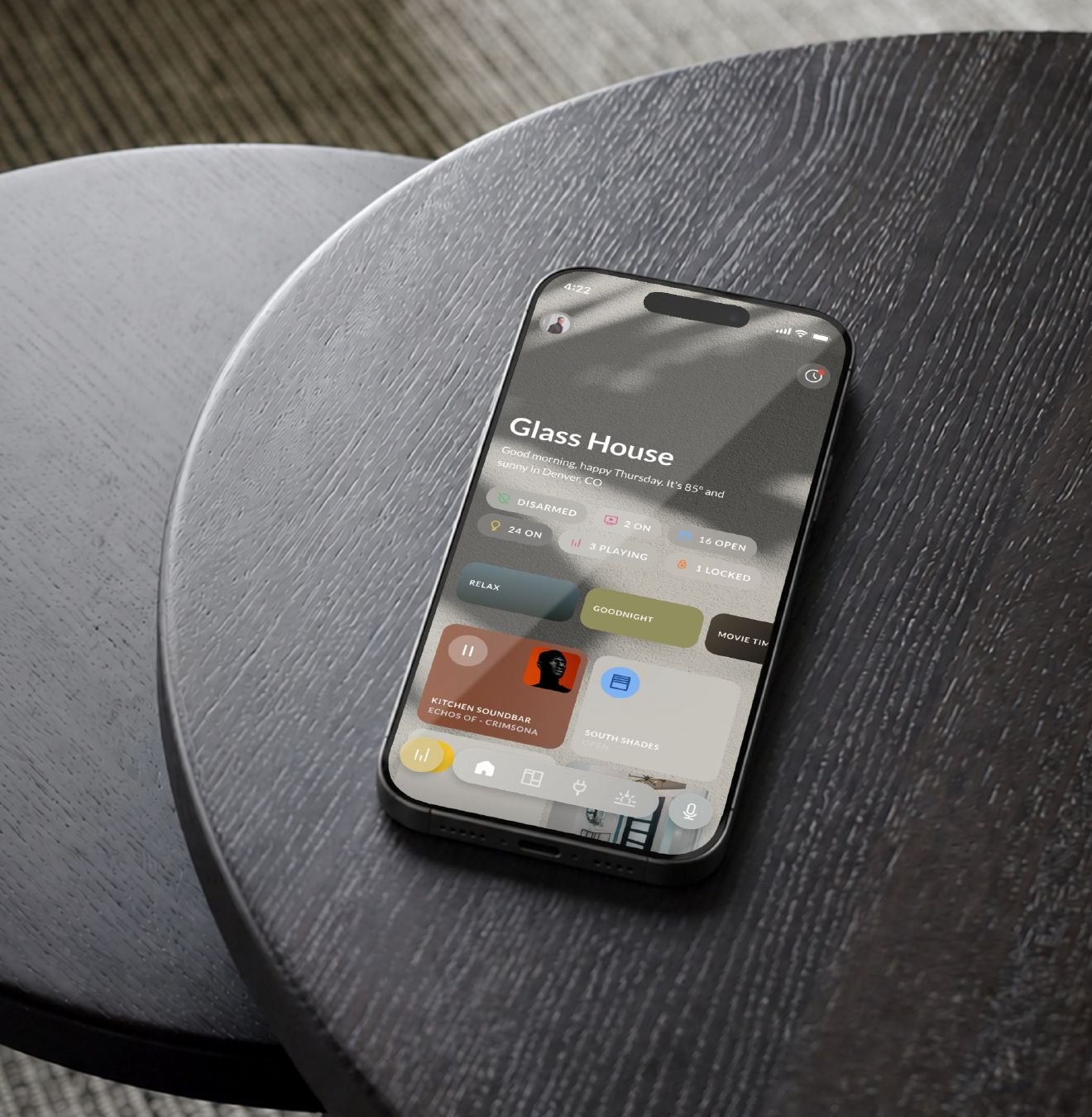Josh.ai app on a phone resting on a side table